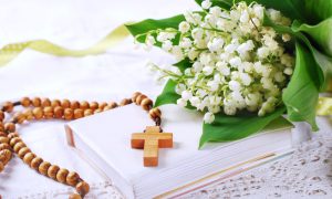 the first holy communion with rosary and flowers